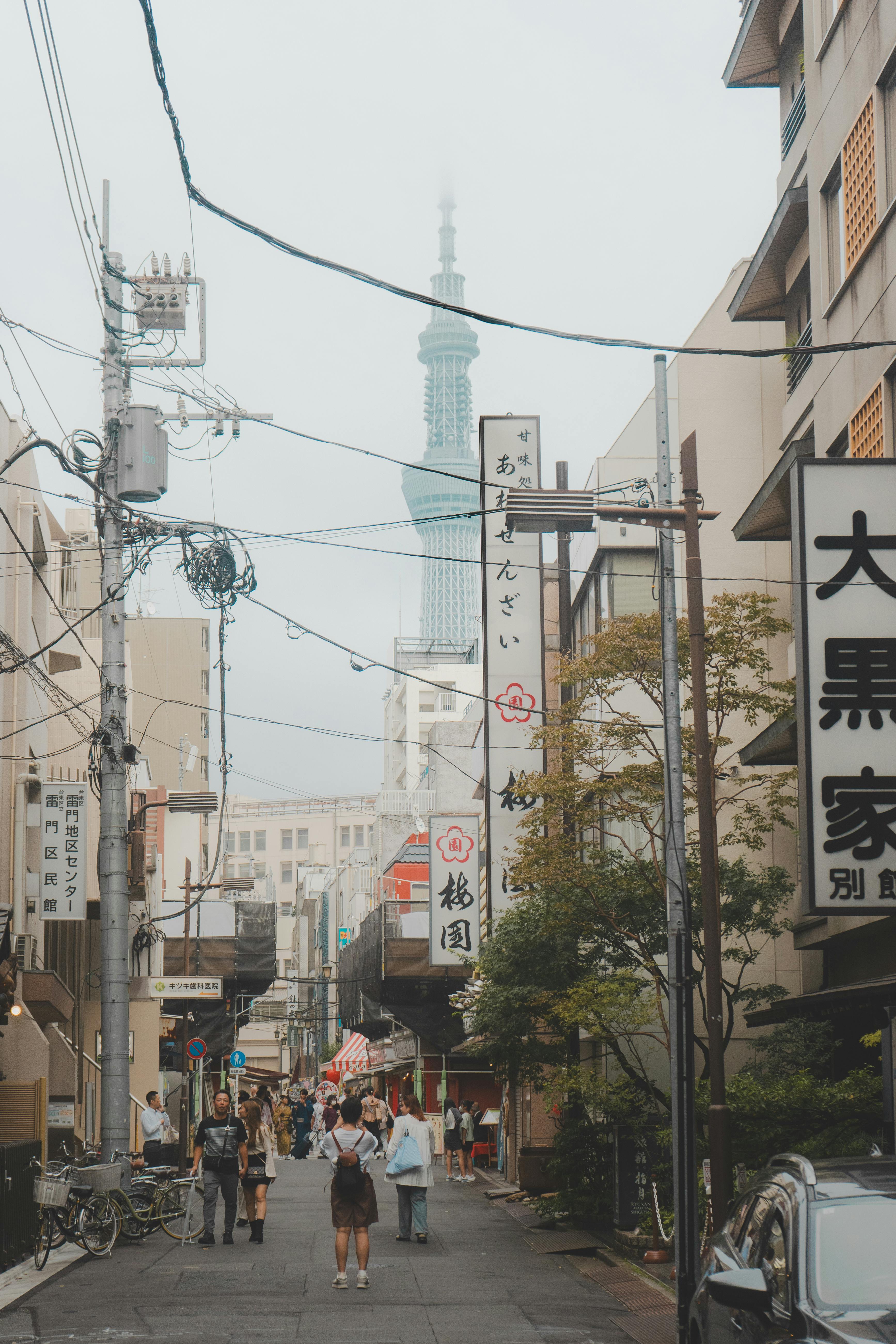 A lively street in Tokyo with a view of the Tokyo Skytree and local shops.