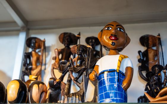 Vibrant wooden African figurines displayed on a shelf, capturing cultural craftsmanship.