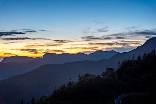 A breathtaking view of the sunrise illuminating a misty mountain range silhouette.