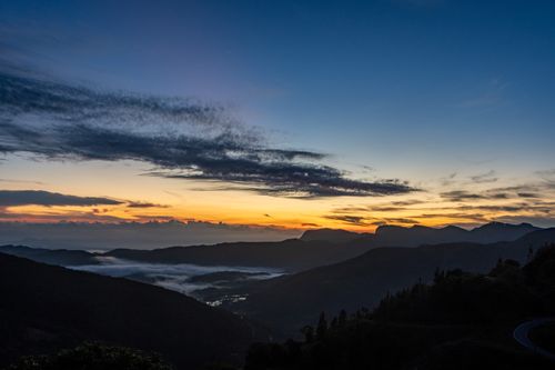 Free Serene mountain sunrise view with vibrant colors and dramatic clouds. Stock Photo