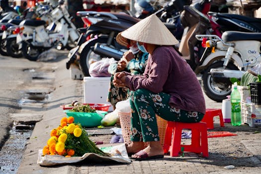A vibrant street market scene featuring vendors in traditional hats selling flowers.