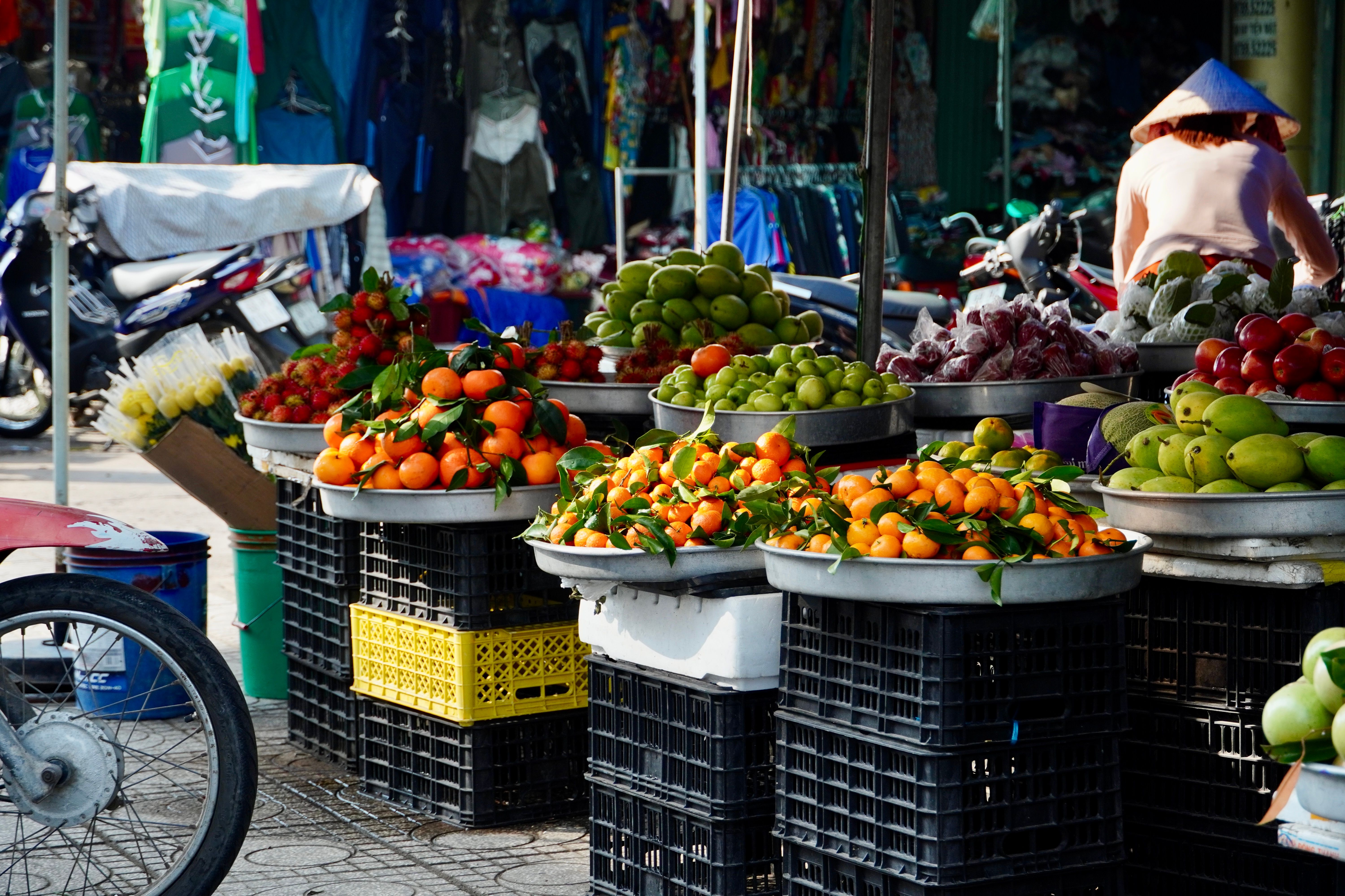 A busy outdoor market with fresh fruits and vegetables in baskets