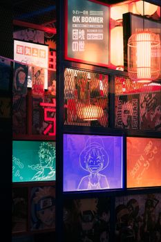 Explore the colorful anime-themed neon signs and lanterns in a Tokyo restaurant.