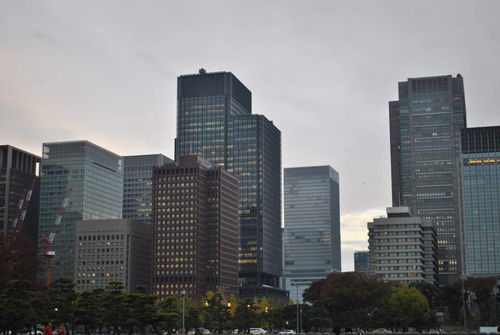 Free Cityscape view of modern skyscrapers at dusk, with a blend of architectural styles and cloudy sky. Stock Photo