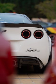 Close-up of a modern white sports car featuring round taillights, showcasing elegant design.