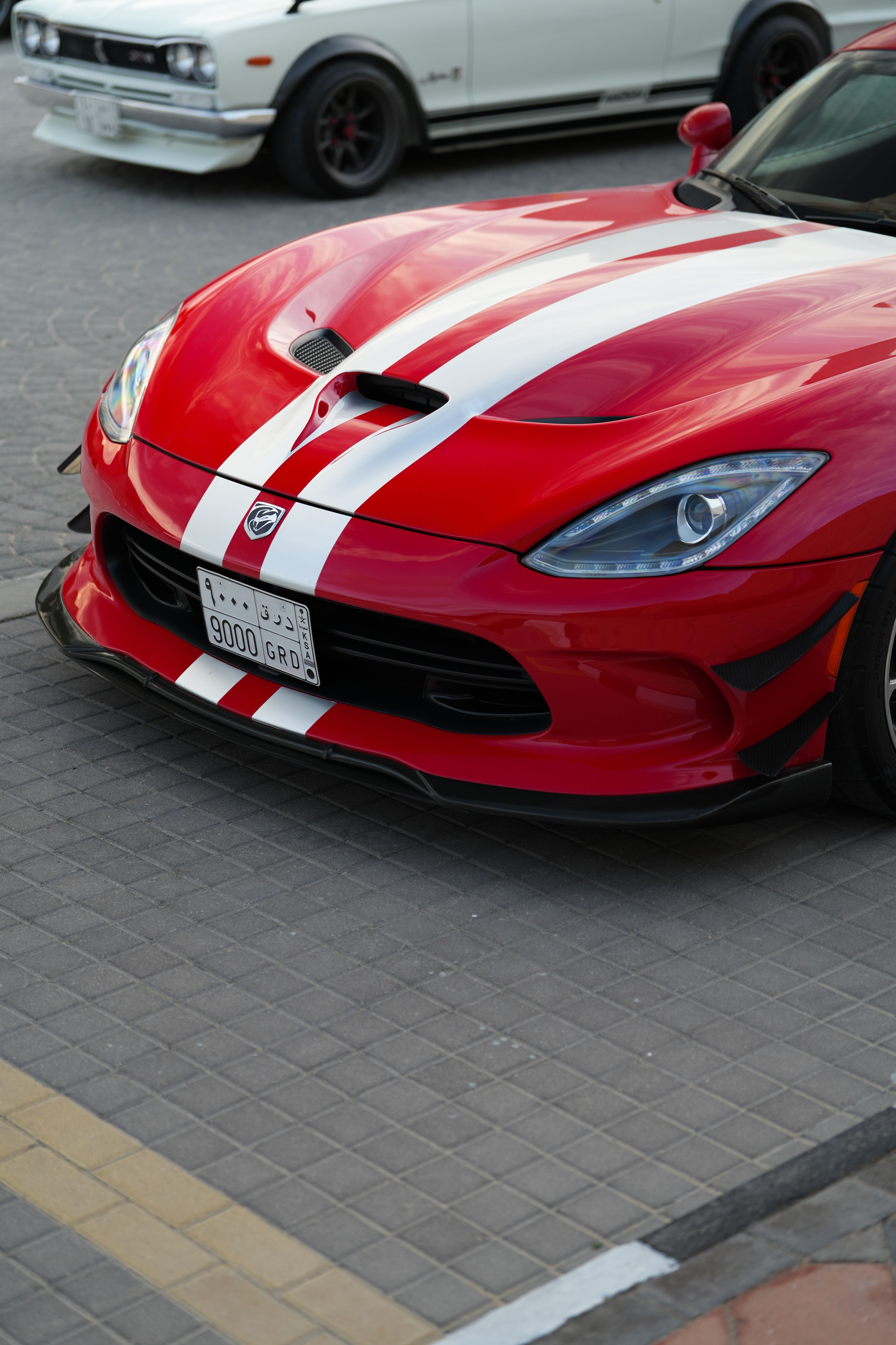 Red Sports Car with Racing Stripes Parked Outdoors · Free Stock Photo