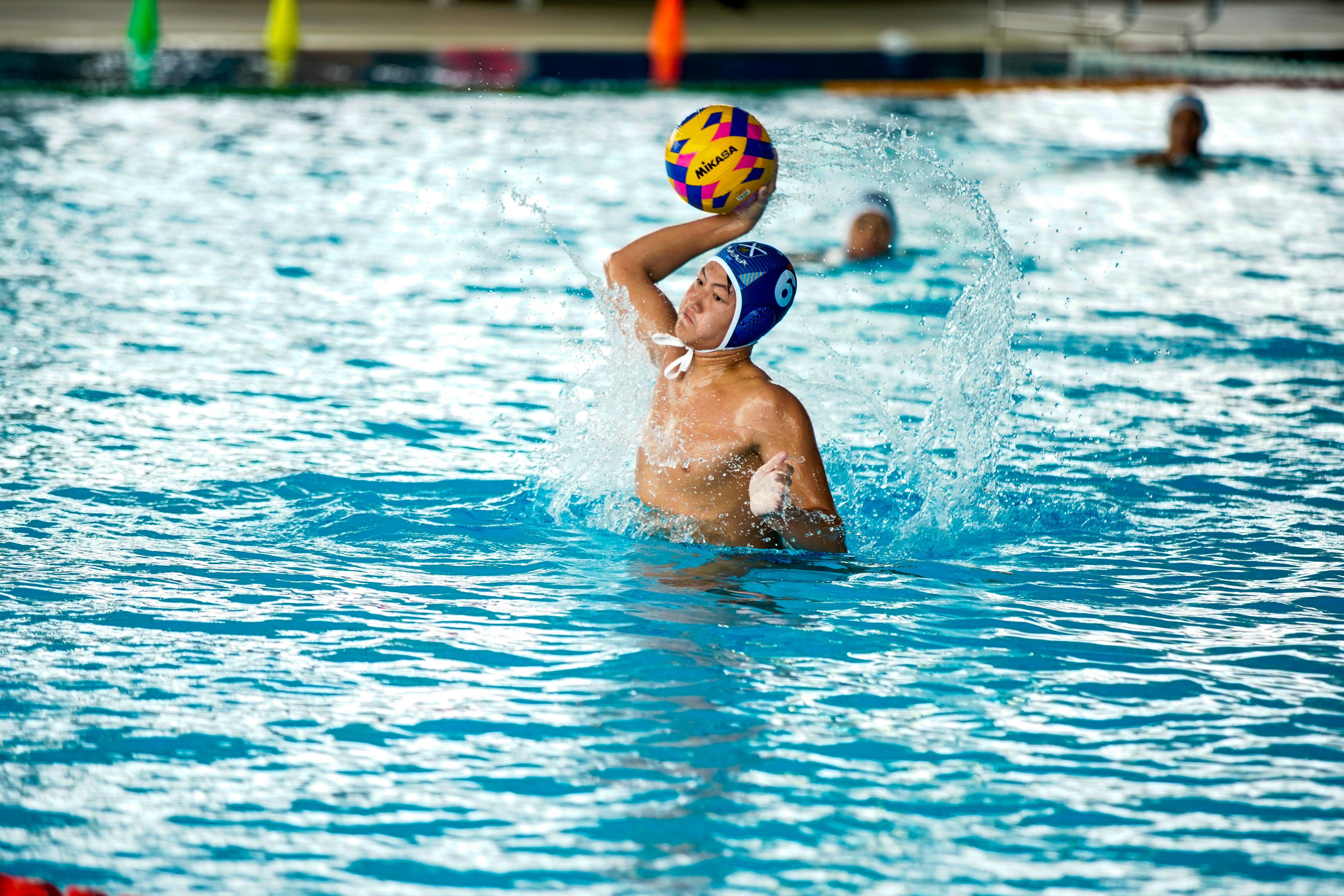 Water Polo Players Treading Water In A Pool, Grappling And Throwing A Ball