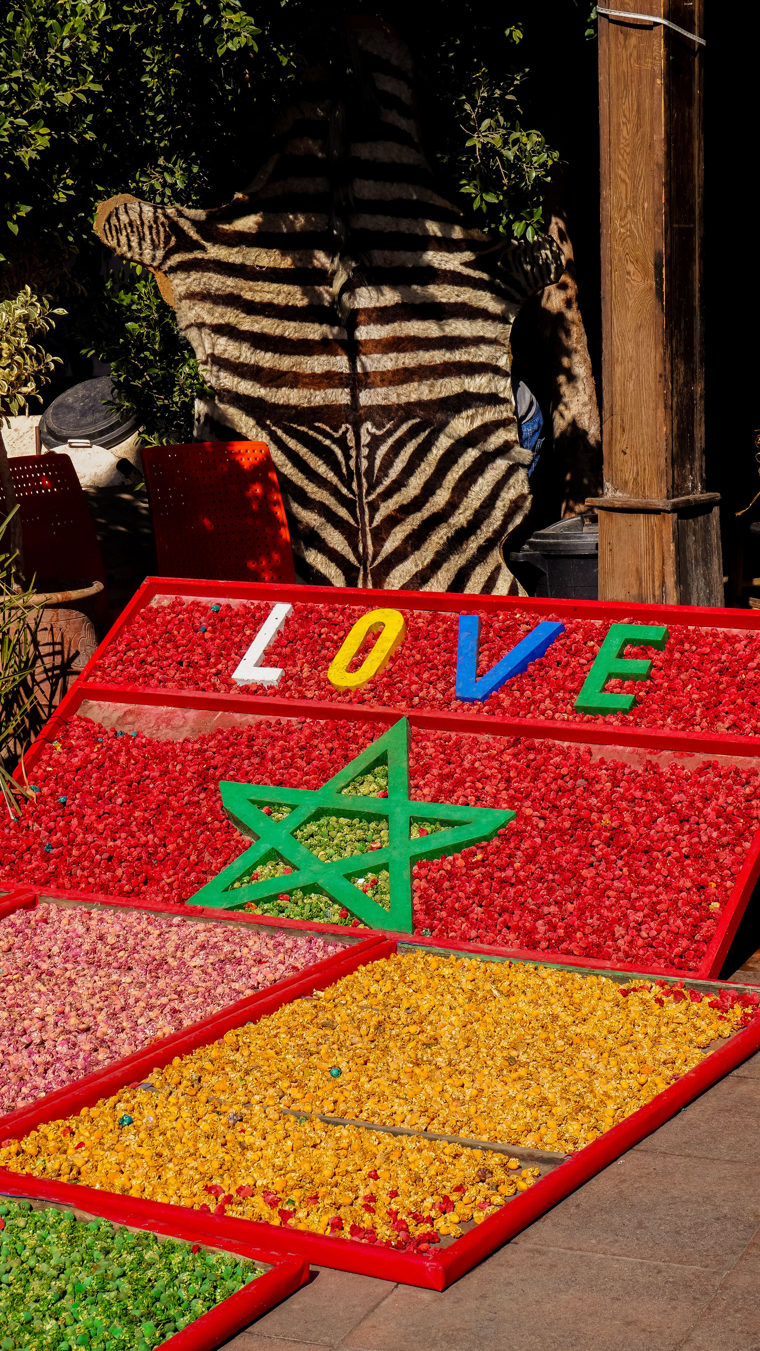 Colorful spice market display in Marrakech featuring Moroccan star and LOVE sign.