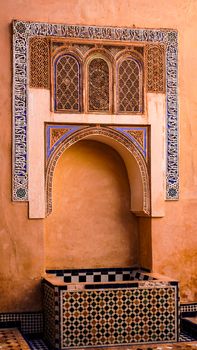 Intricate Moroccan architectural details in a wall fountain in Marrakesh, showcasing rich traditional design.