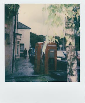 怀旧的街景，以红色复古电话亭和潮湿的人行道为特色