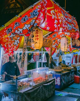 Colorful street food stall at a Japanese night market, bustling with activity.