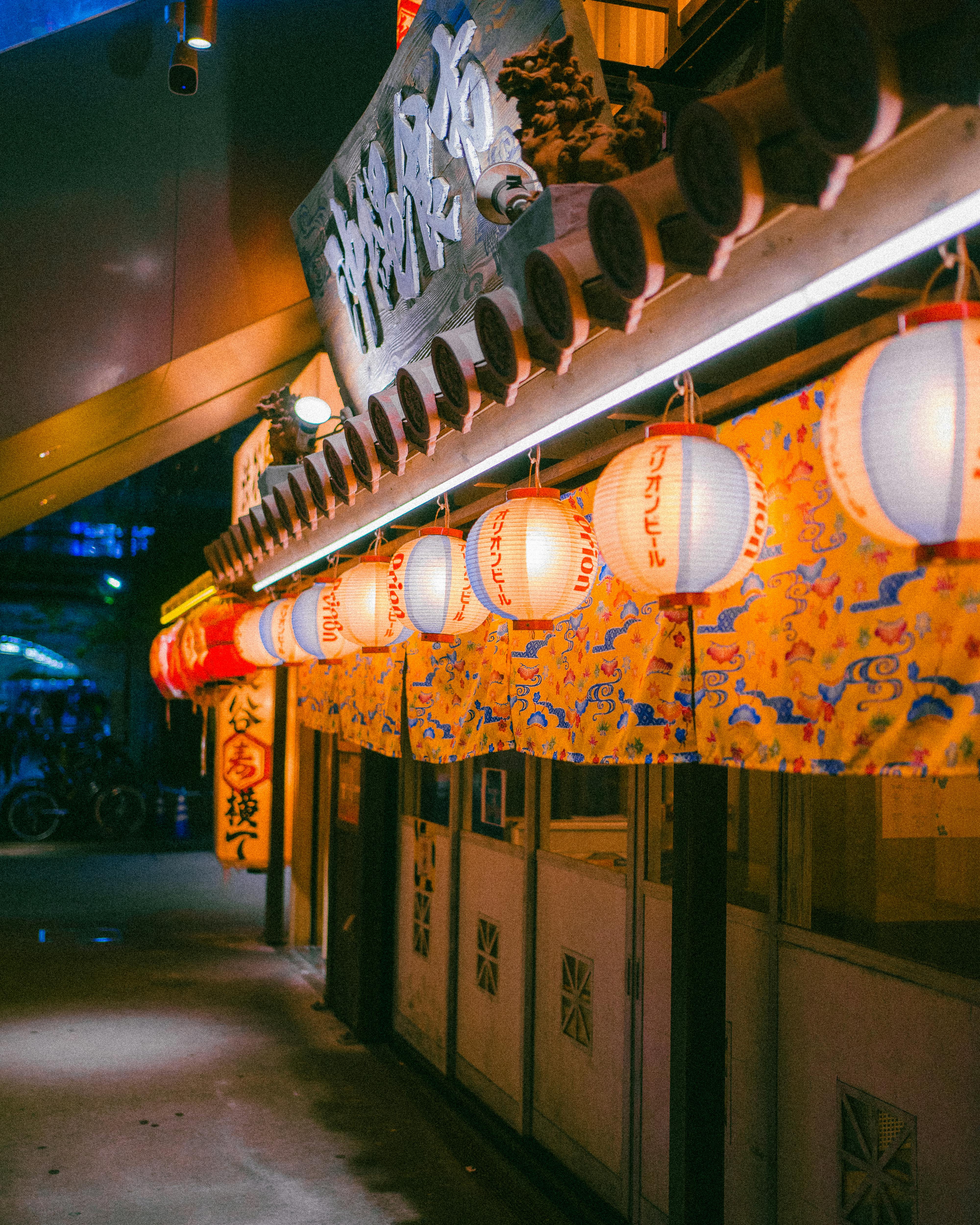 Traditional Japanese street scene with illuminated lanterns at night.