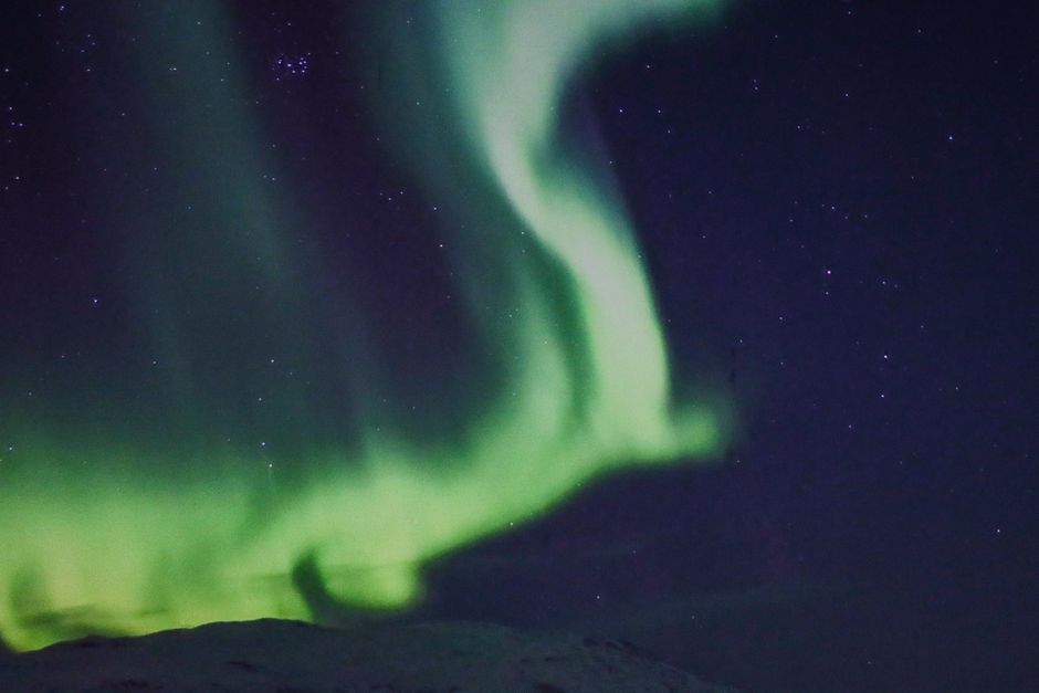 Capture of the mesmerizing green aurora borealis dancing over Tromsø, Norway.