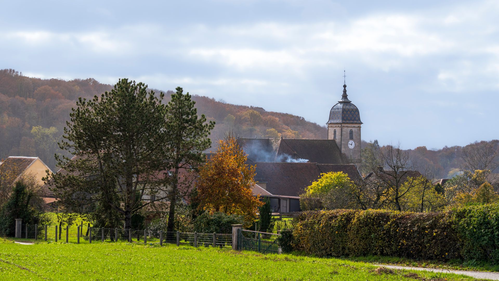 A village in southwest France on a late autumn morning, woodsmoke rising