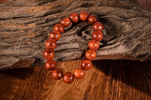 Free Round wooden bead bracelet resting on aged rustic wooden surface, offering an earthy aesthetic. Stock Photo