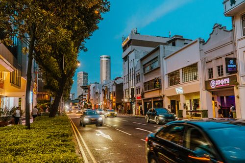 Free Vibrant urban scene showing busy street, historic architecture, and city life at dusk. Stock Photo