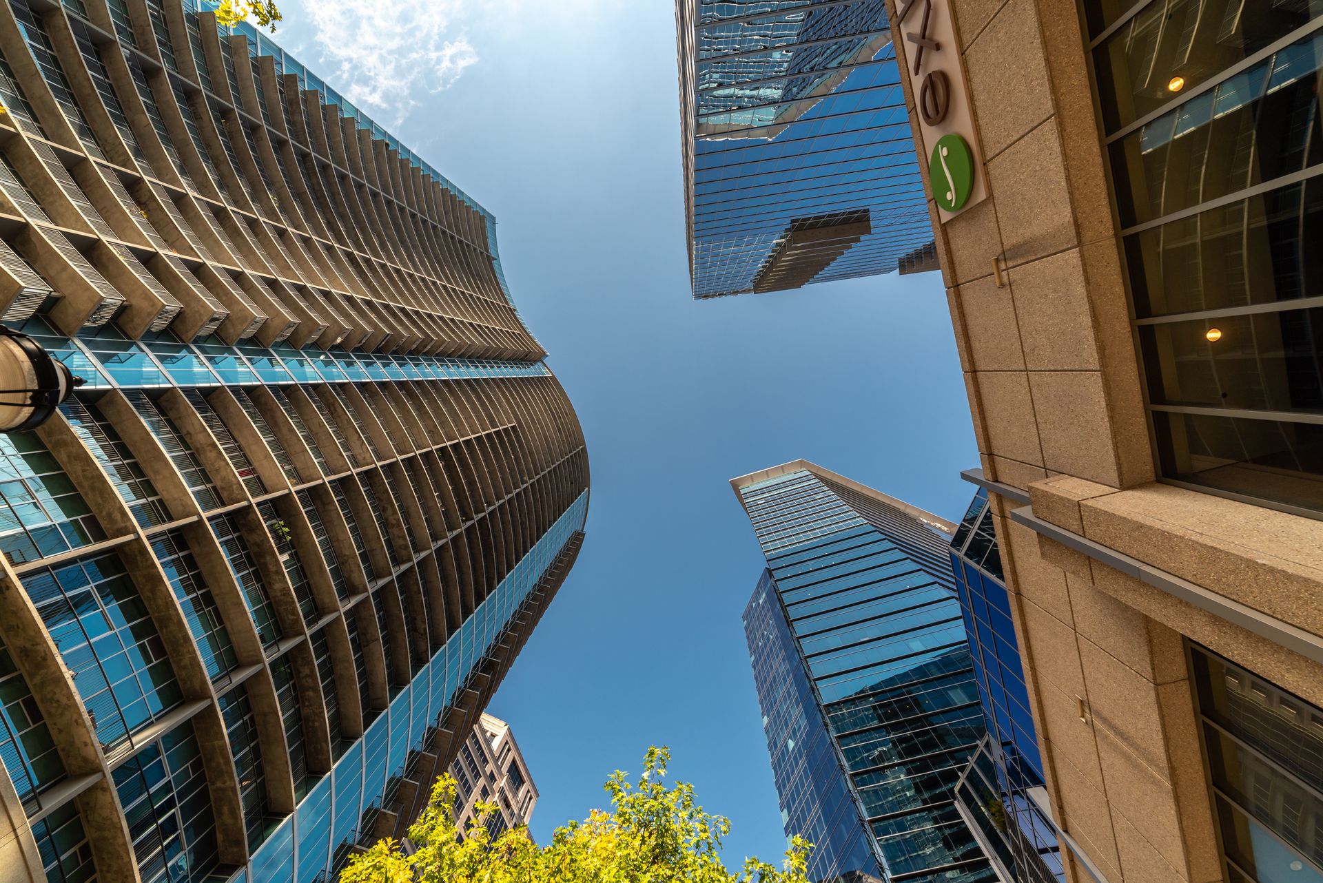 Upward view of modern Atlanta skyscrapers and high-rise buildings against a clear blue sky, capturing the urban architecture of downtown Atlanta