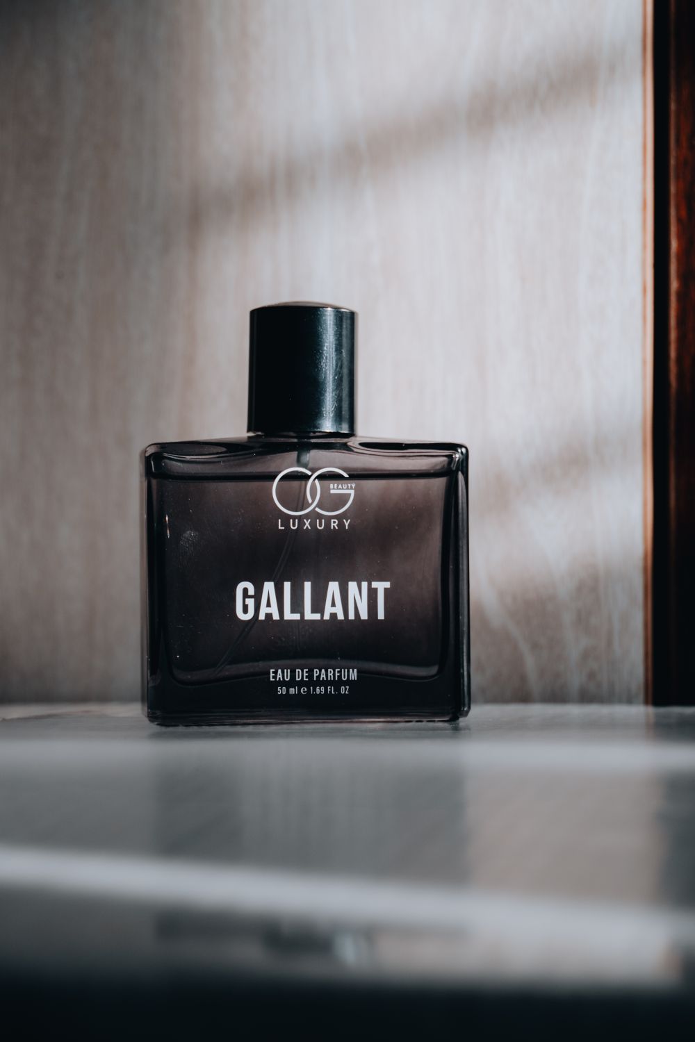 Minimal dark glass perfume bottle with moody highlights
