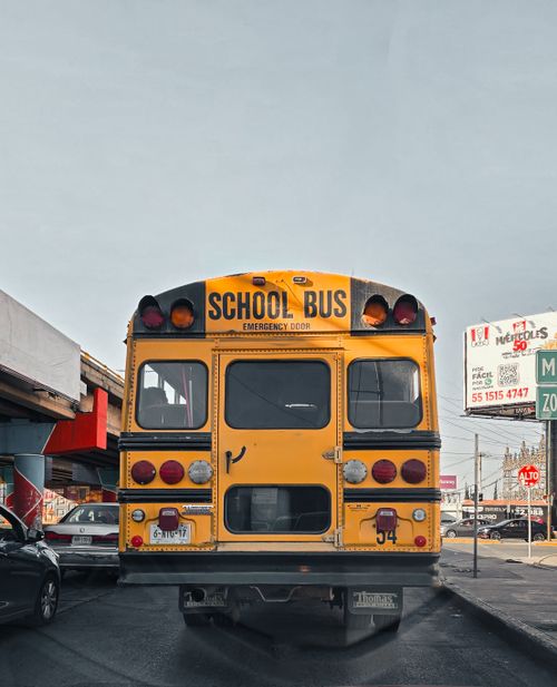 Free Rear view of a yellow school bus on a busy street in San Luis Potosí, México. Stock Photo