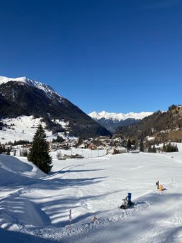 Beautiful snowy scene of Swiss Alps with clear blue sky and mountainous backdrop.