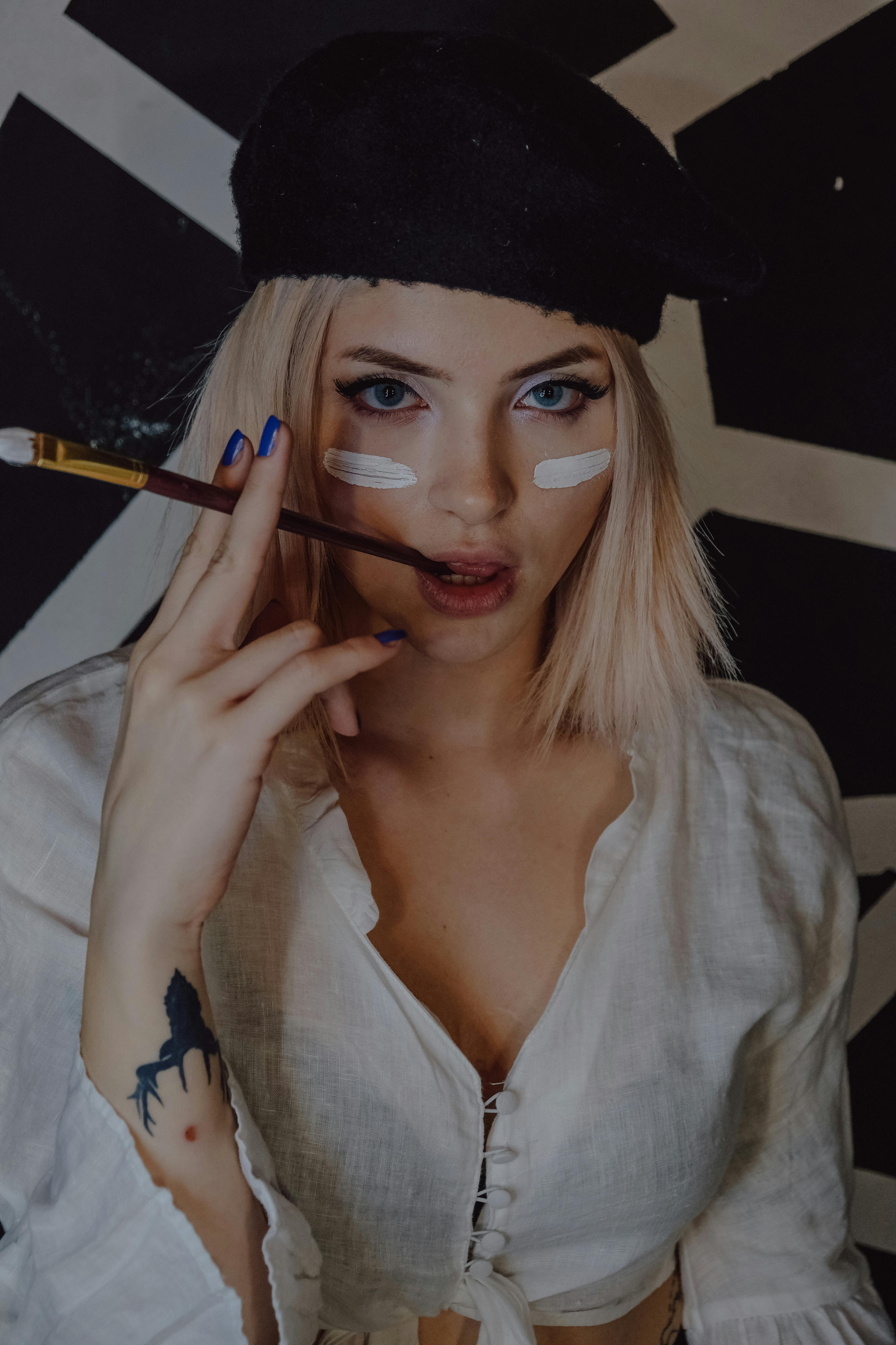 Miễn phí Chân dung một nghệ sĩ thời trang với khuôn mặt đầy màu sơn, đội mũ nồi và cầm cọ vẽ. Ảnh lưu trữ