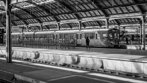 Free Monochrome image of a train at a station with a solitary figure. Stock Photo