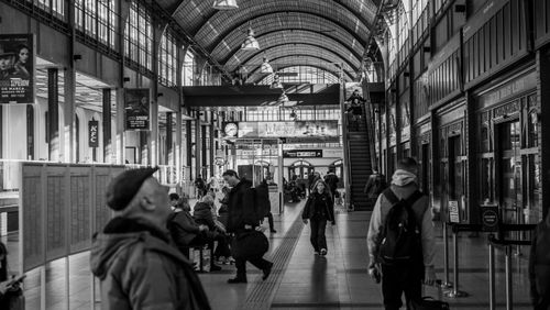 Free Monochrome capture of a busy train station with people moving and waiting. Stock Photo