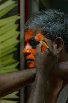 Close-up of intricate face painting being applied for a cultural performance.