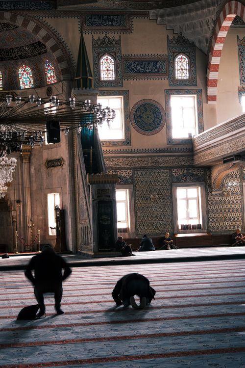 Free A serene moment inside a beautifully decorated mosque with people praying. Stock Photo