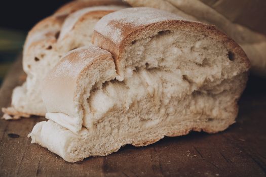 Close-up of rustic homemade bread with a golden crust on wooden board.