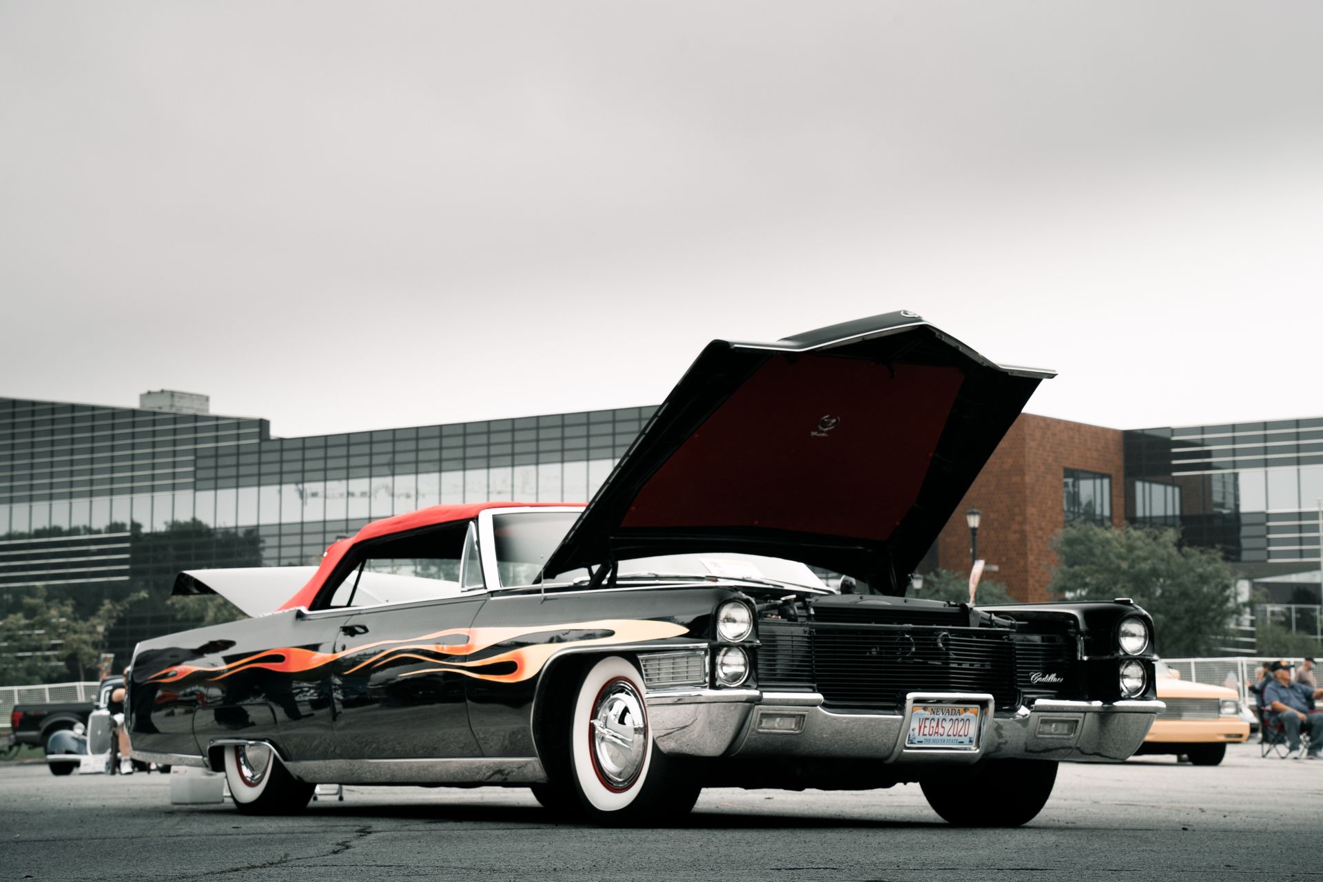 Classic American car with hood up, showcasing vintage design at an auto show.