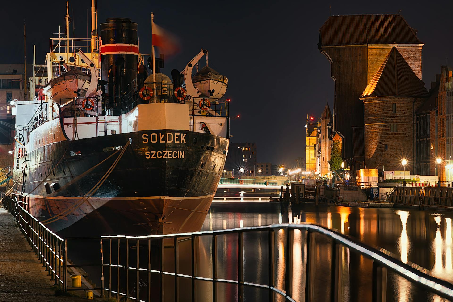 Elegant nighttime view of the SS Sołdek ship and the waterfront in Gdańsk, Poland.