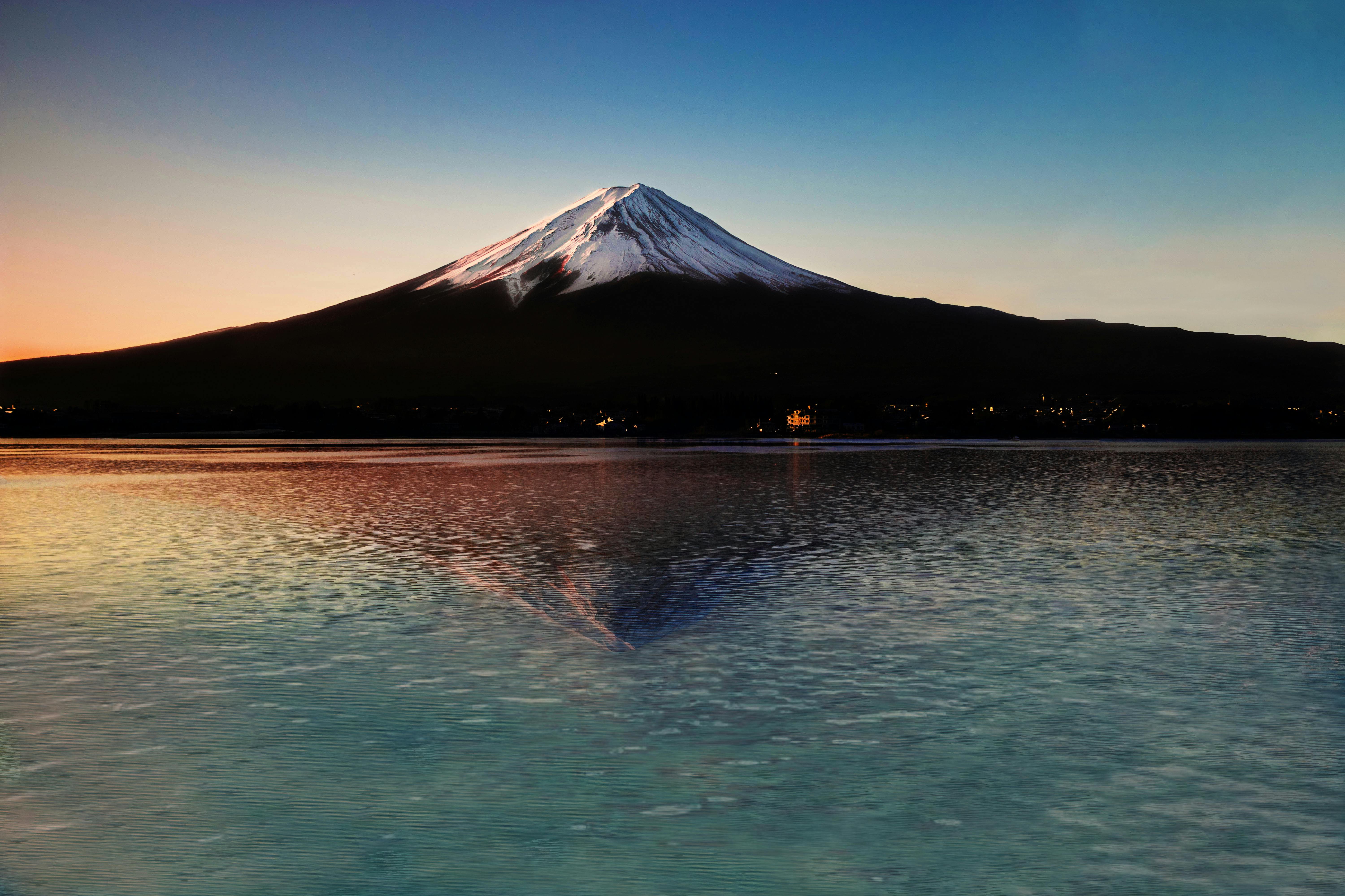 Breathtaking view of Mount Fuji at sunset with a serene lake reflection, capturing Japan's natural beauty.