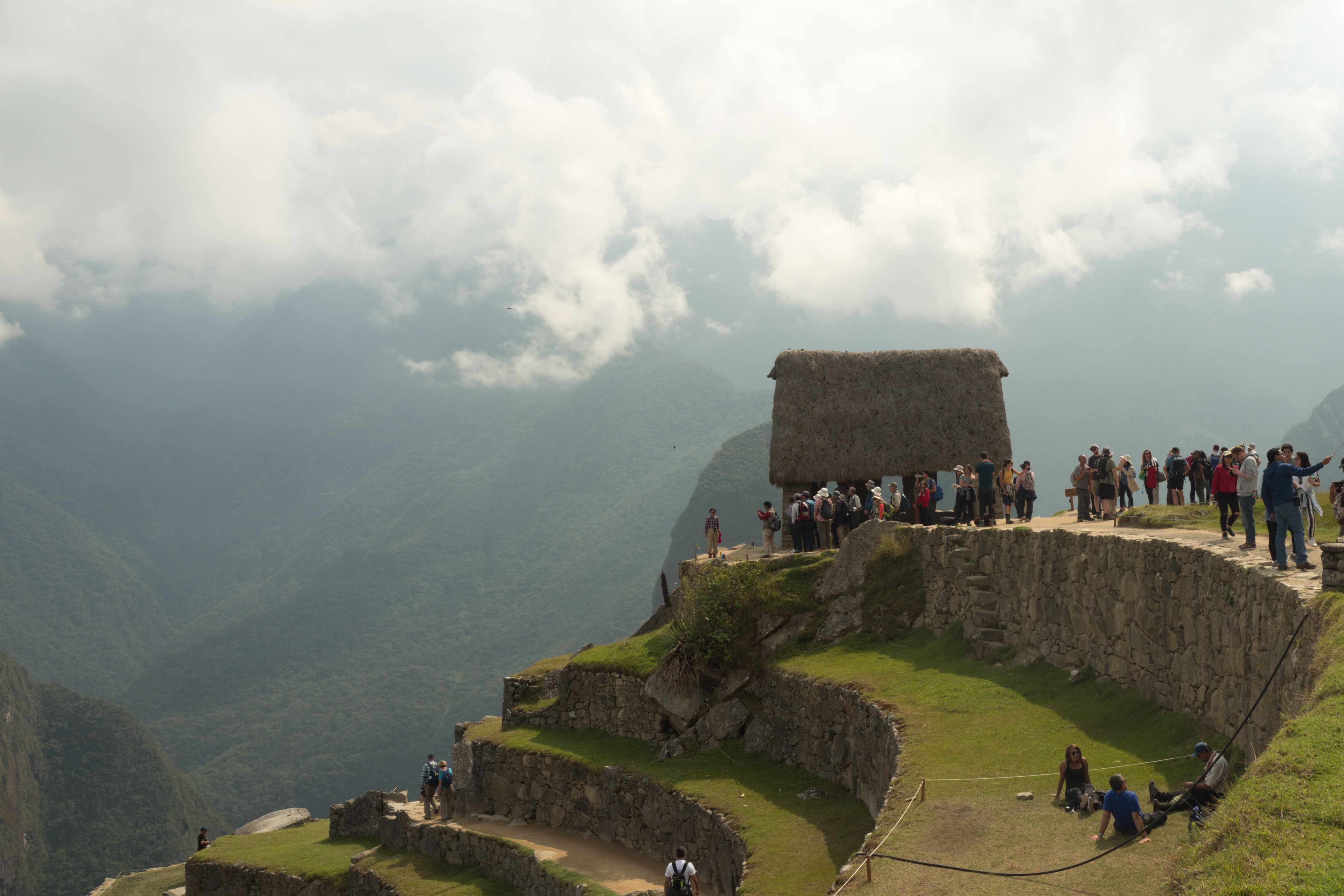 Tourists enjoying the scenic views from Machu Picchu's ancient terraces in Cusco, Peru. Tourists enjoying the scenic views from Machu Picchu's ancient terraces in Cusco, Peru.