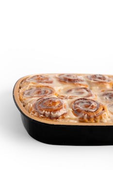 Close-up of a tray of glazed cinnamon rolls, freshly baked and ready to enjoy.