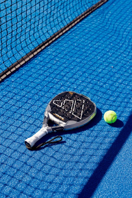 Padel Racket and Ball on Blue Court Surface · Free Stock Photo