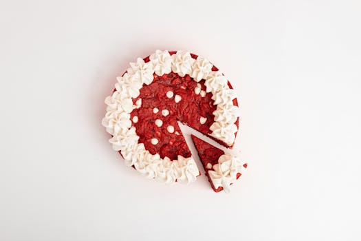 Appetizing red velvet cake with cream frosting on white background. A slice is cut out.