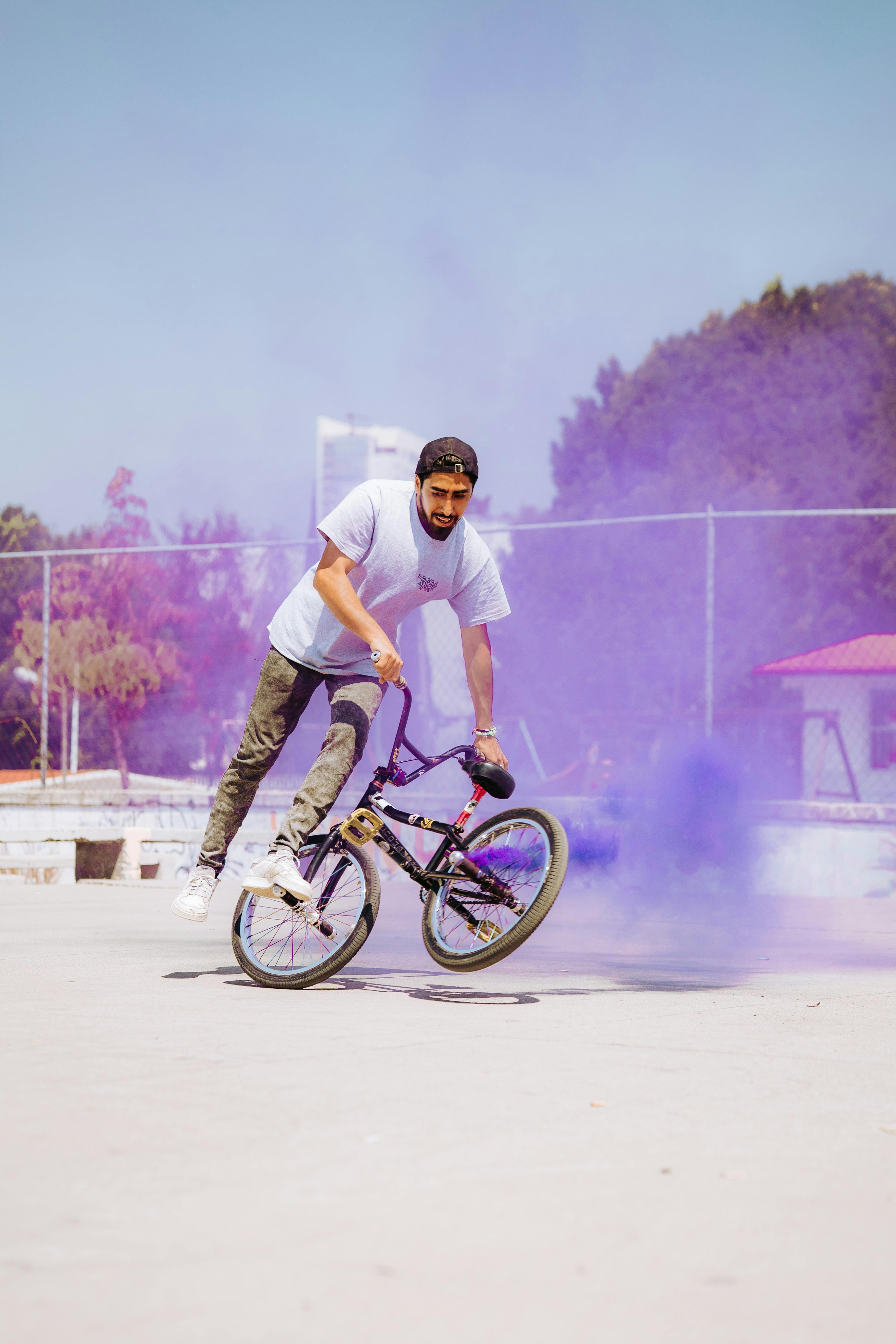 A BMX rider performs an exciting trick amidst vibrant purple smoke in Heroica Puebla de Zaragoza, Mexico.