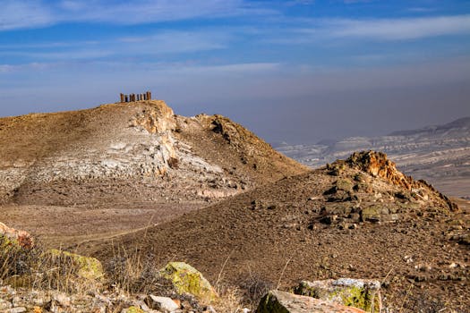 Explore the rugged beauty of Cappadocia's hills and unique monoliths under a clear sky.