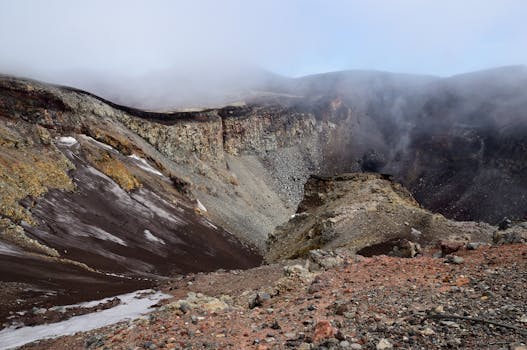 Explore the awe-inspiring volcanic crater surrounded by mist in this dramatic landscape.