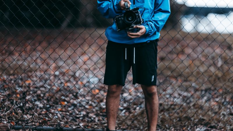 homeowner photographing the wires behind an old wall thermostat with a phone