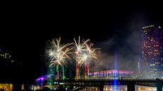 Vibrant fireworks illuminate the night sky over a bustling cityscape, creating a stunning visual display.