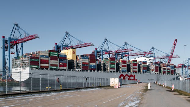 A container ship docked at a bustling shipping terminal in Hamburg, Germany.