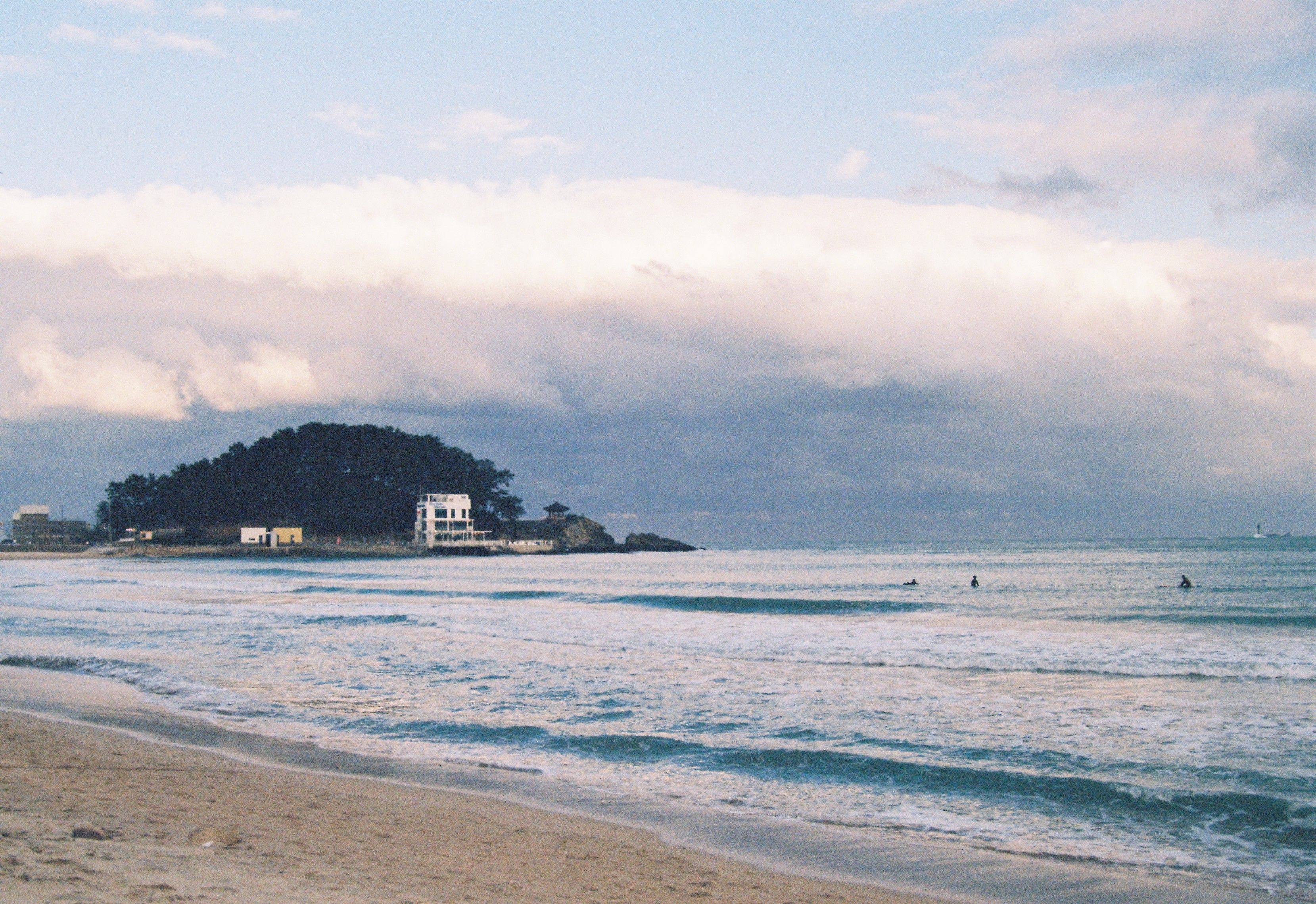 Peaceful beach scene with gentle waves and cloudy skies, ideal for relaxation themes.