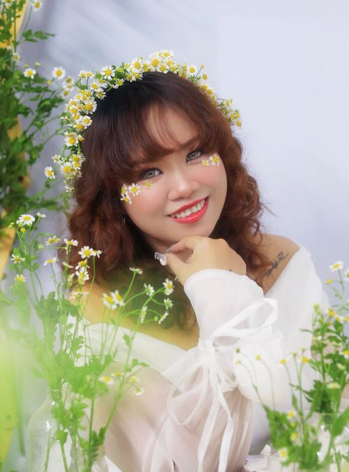 Free Charming woman with a flower crown, surrounded by vibrant flowers, exuding joy and springtime energy. Stock Photo