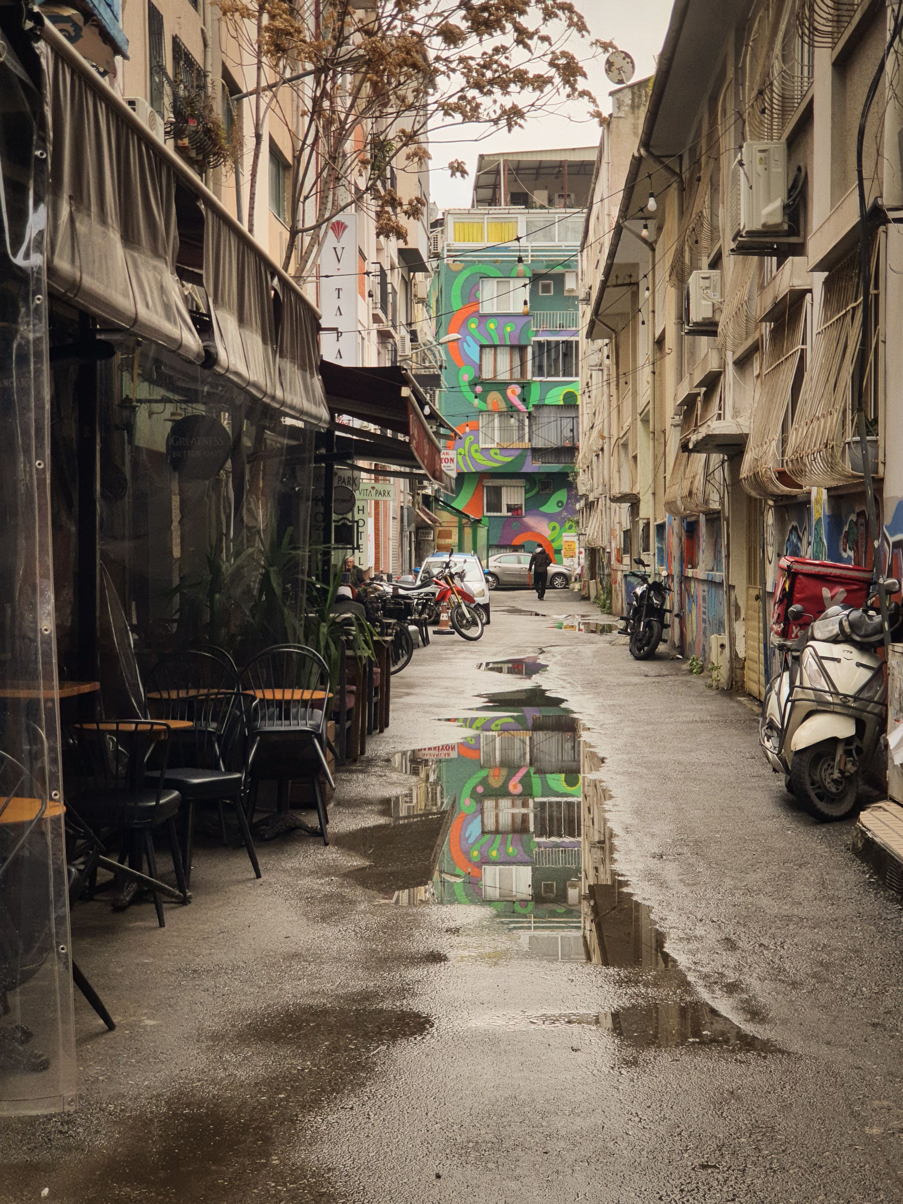 Vibrant Urban Alley with Street Art in Rain · Free Stock Photo