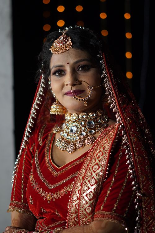 Free A stunning Indian bride adorned with traditional jewelry and red bridal attire captured in an elegant pose. Stock Photo