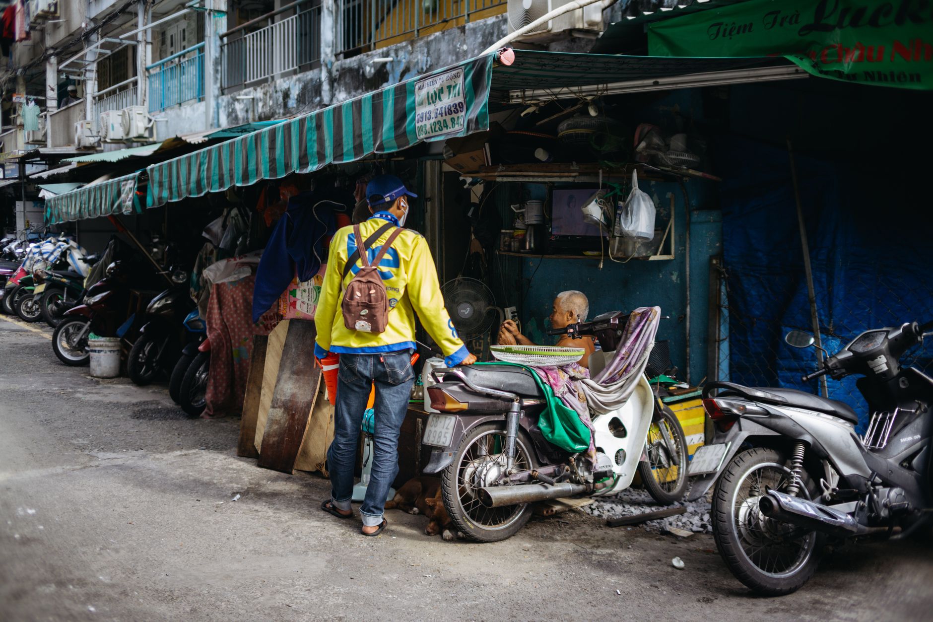 A busy Asian street market with motorcycles and vendors, showcasing vibrant daily life.