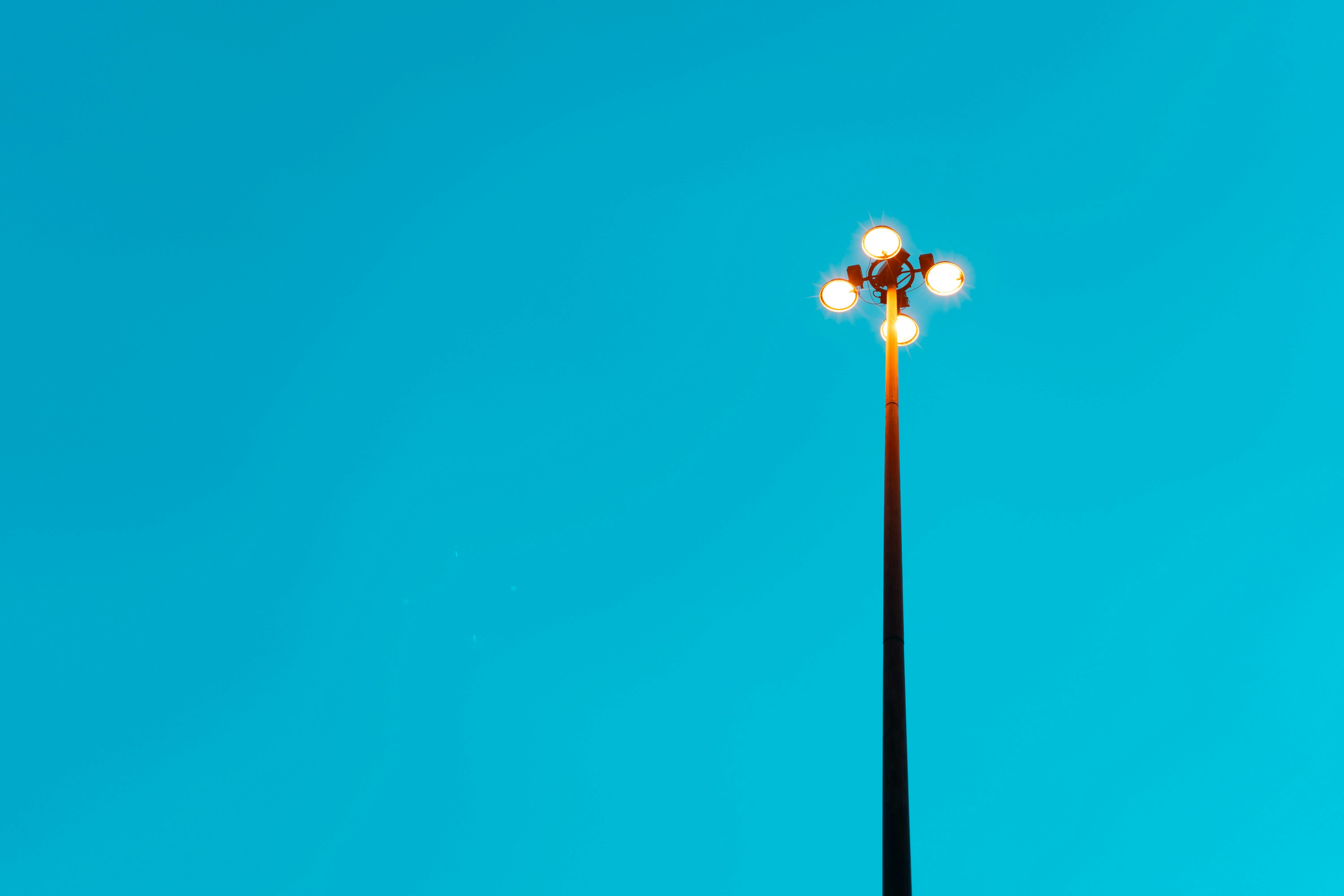 Free A tall streetlight stands against a bright clear blue sky creating a minimalist aesthetic. Stock Photo