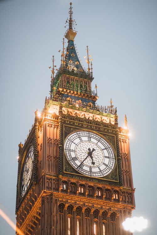 Free Iconic Big Ben tower glowing at dusk in London, capturing its intricate architectural details. Stock Photo